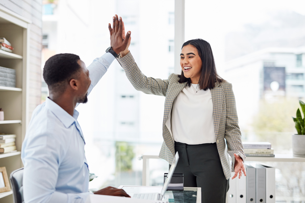 Shot of two businesspeople giving each other a high five in an office